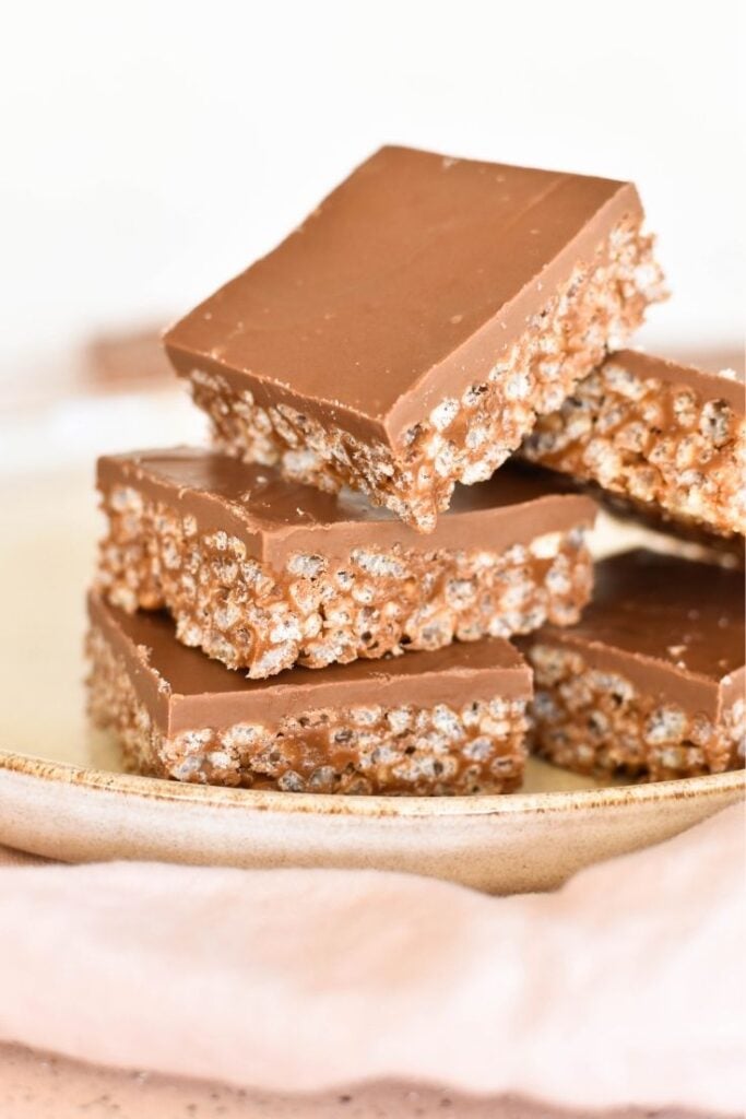 mars bar slice pieces sitting on plate with cloth in foreground