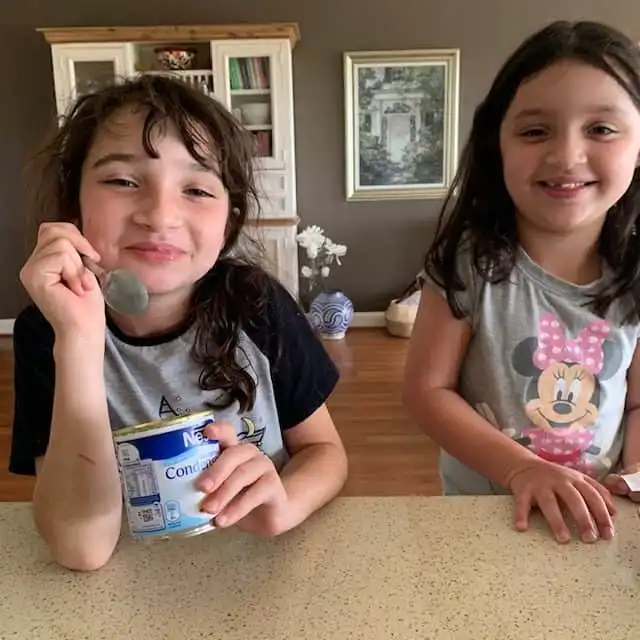 girls eating condensed milk from tin