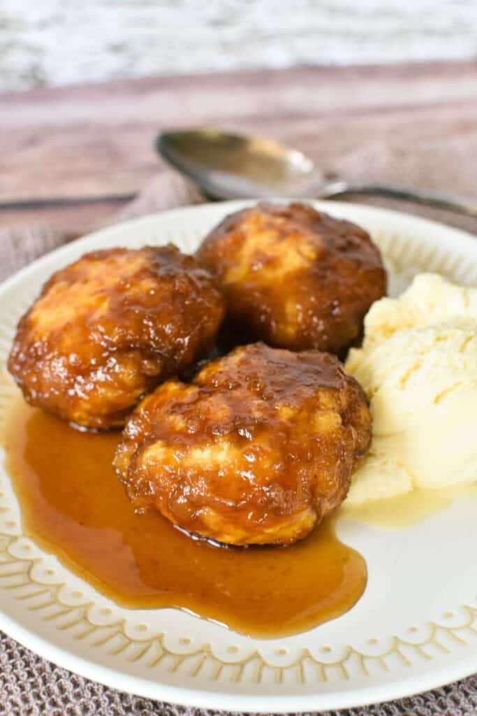 Golden Syrup Dumplings on a plate served with ice cream.