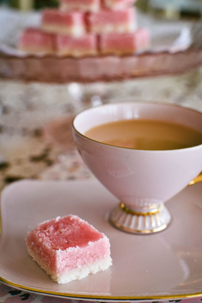 piece of coconut ice served with cup of tea.