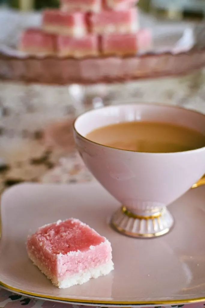 piece of coconut ice served with cup of tea.