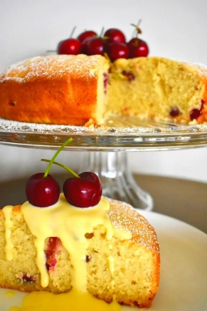 cherry cake on stand with slice in foreground