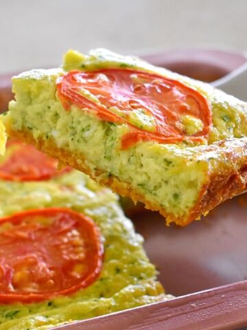 zucchini slice being lifted from tray