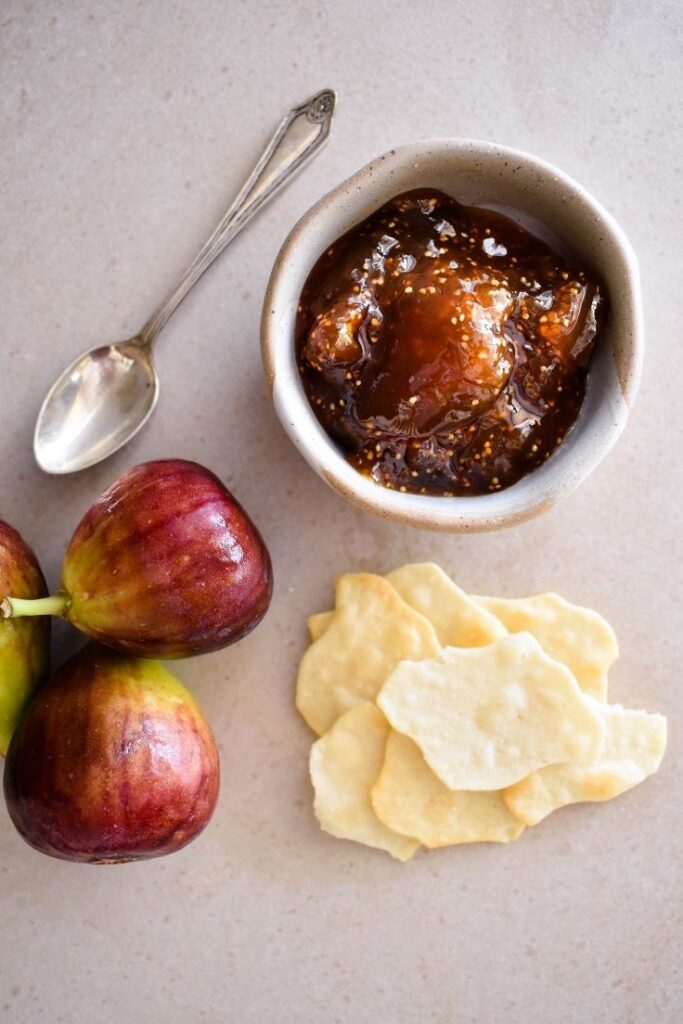 fig jam in bowl with crackers and fresh figs in display