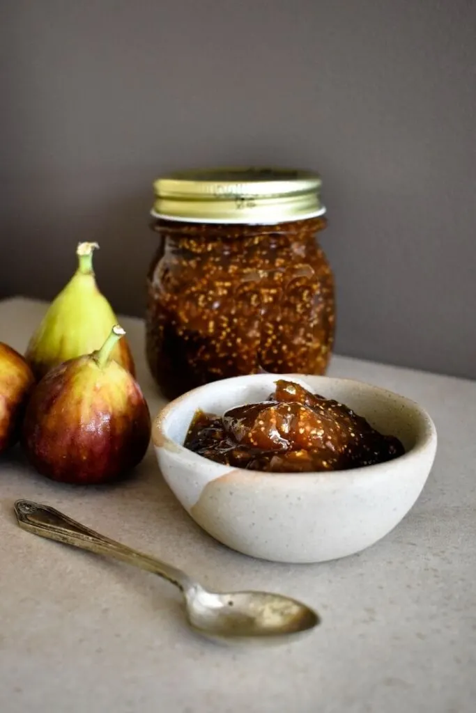 fig jam on bench with two fresh figs