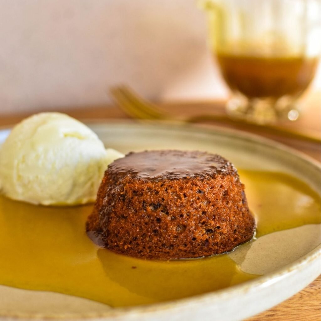 sticky date pudding on plate with sauce.