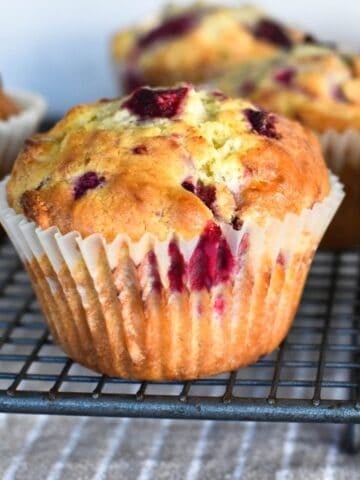 Raspberry and white chocolate muffin on cooling tray.