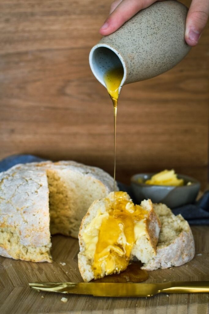 golden syrup being poured over damper