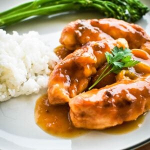 apricot chicken on plate with rice and veges.