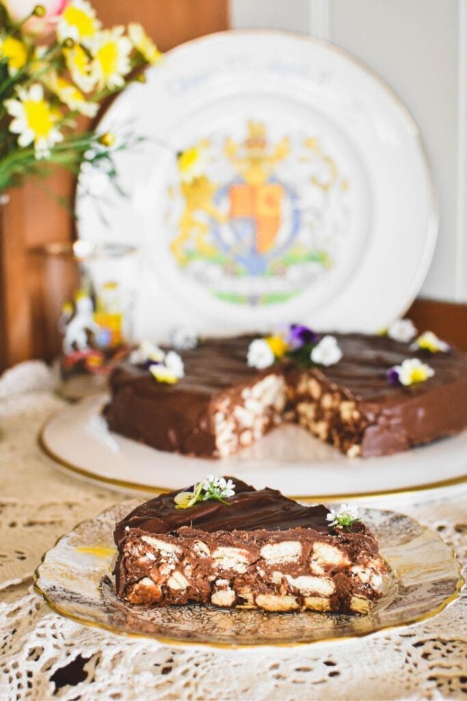 chocolate biscuit cake slice with whole cake in background