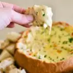 cob loaf recipe with bread dipping into cob loaf.