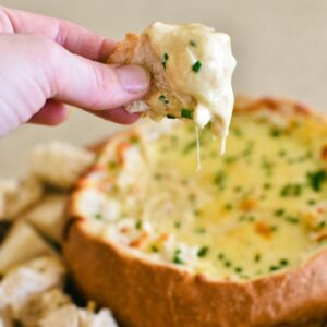 cob loaf recipe with bread dipping into cob loaf.