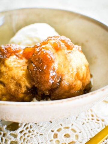 golden syrup dumplings in bowl with ice cream.