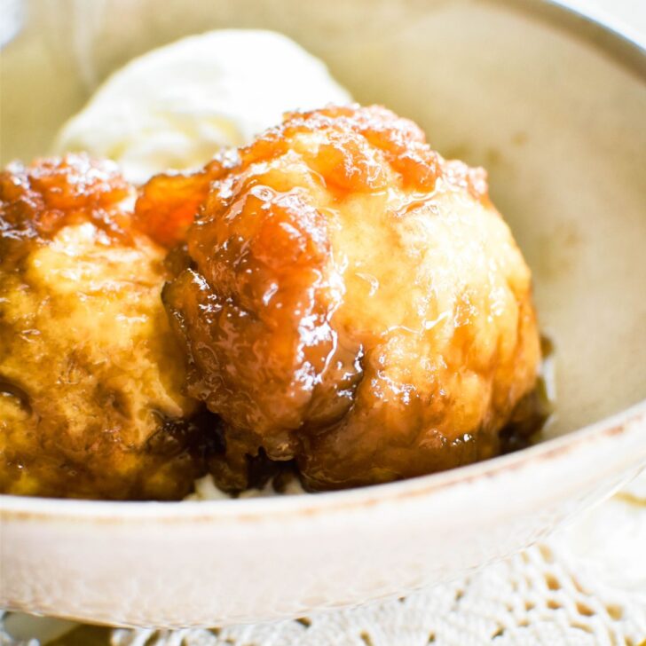 golden syrup dumplings in bowl with ice cream.