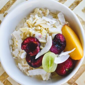 bircher muesli in bowl topped with fruit and nuts.