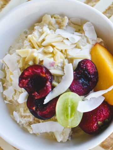 bircher muesli in bowl topped with fruit and nuts.