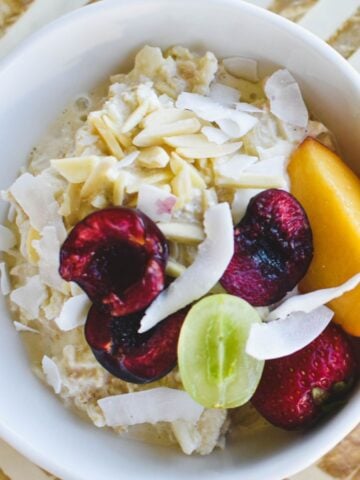 bircher muesli in bowl topped with fruit and nuts.