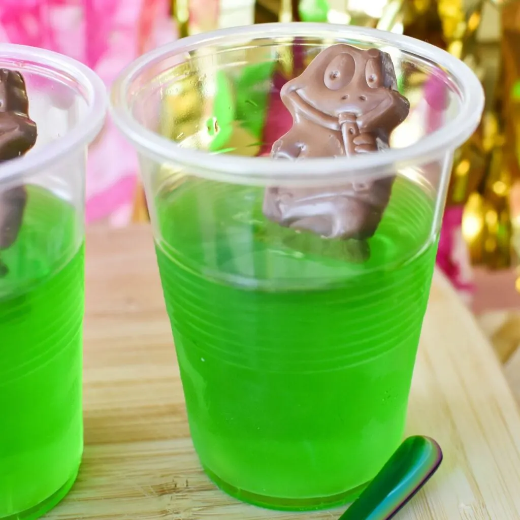 frog in a pond dessert, made of a chocolate frog sitting in green jelly in a clear plastic cup.