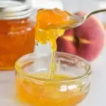 peach jam in bowl with spoon.