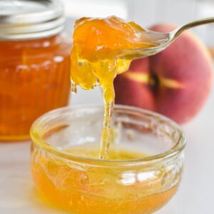 peach jam in bowl with spoon.