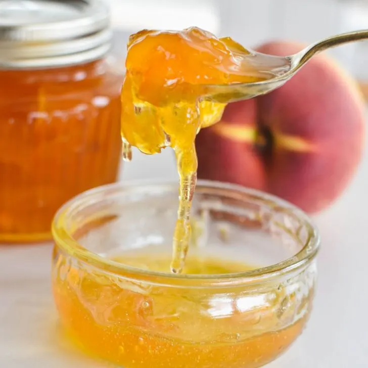 peach jam in bowl with spoon.
