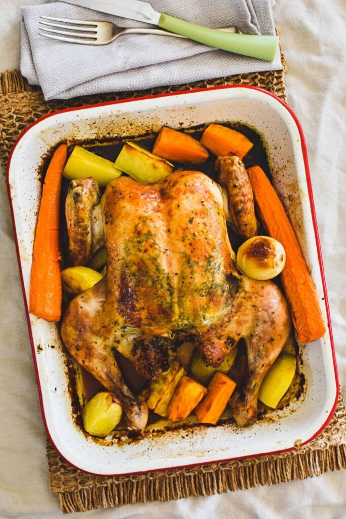 butterfly chicken in baking dish with veges.