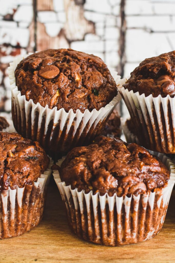 chocolate zuchhini muffins on wooden serving board.