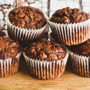 chocolate zuchhini muffins on wooden serving board.