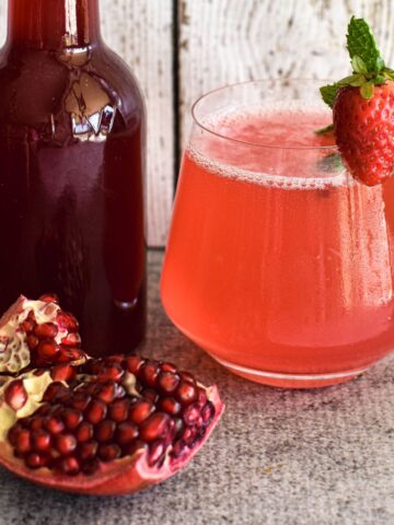 pomegranate cordial in bottle with drink using cordial.
