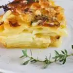 potato bake -slice showing layers of potatoes and cheese and cream.