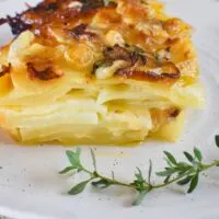potato bake -slice showing layers of potatoes and cheese and cream.