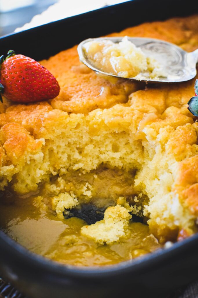 butterscotch pudding in baking dish with sauce oozing out.