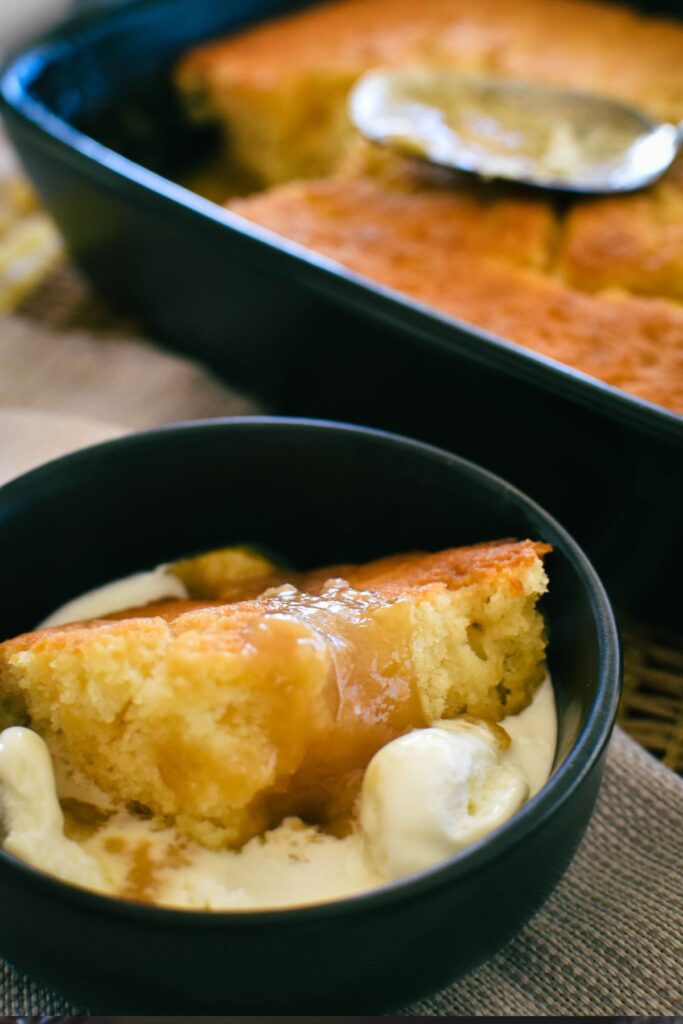 bowl of butterscotch self saucing pudding served with ice cream.