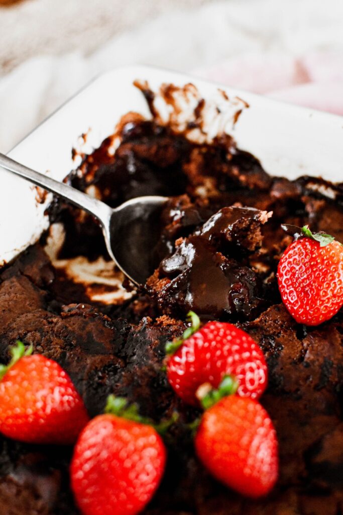 scoop of chocolate self saucing pudding showing chocolate sauce.