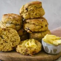 date scones on wooden board with butter in small condiment container.