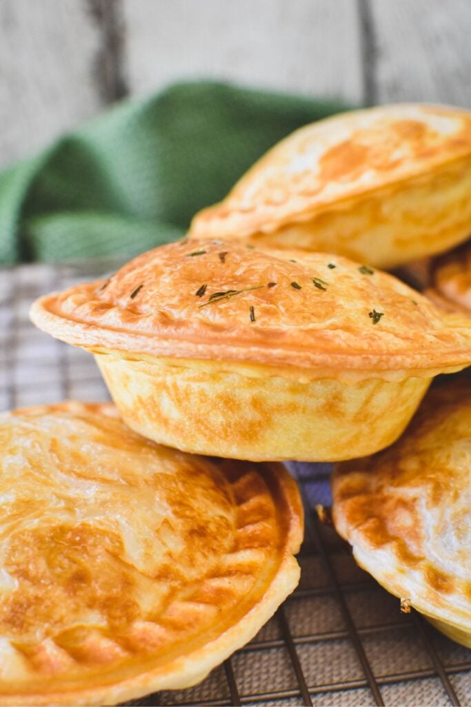 chicken and leek pies stacked on counter.