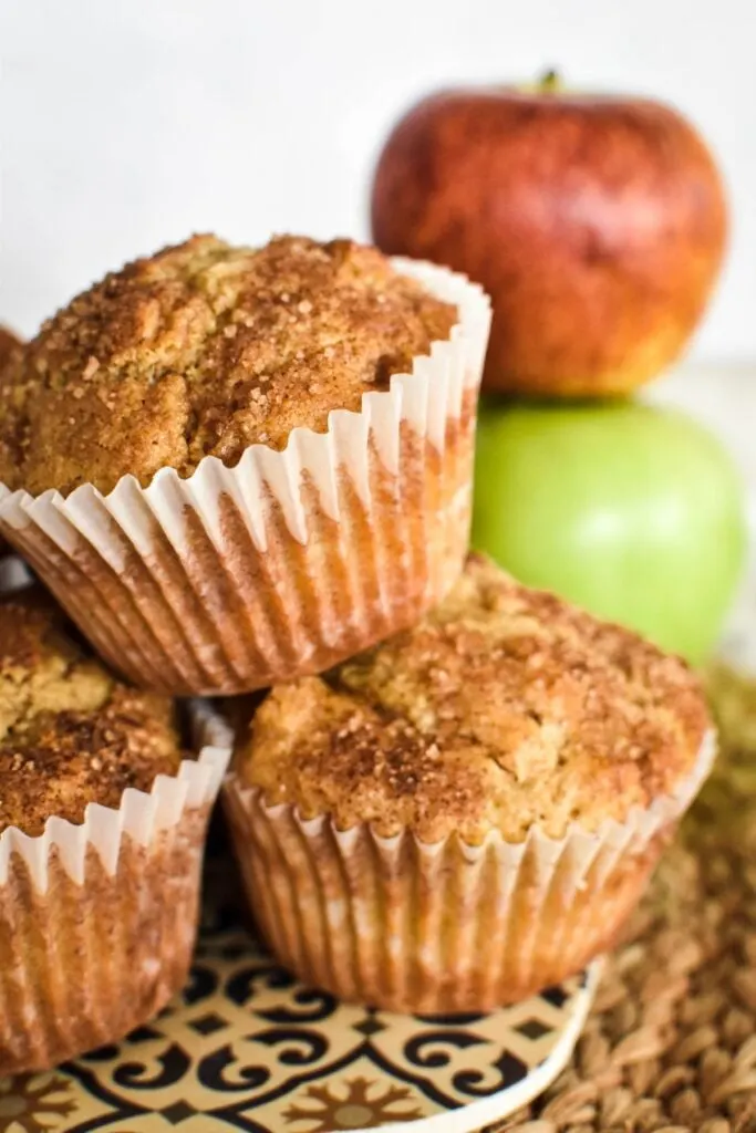 apple cinnamon muffins with apples in background.