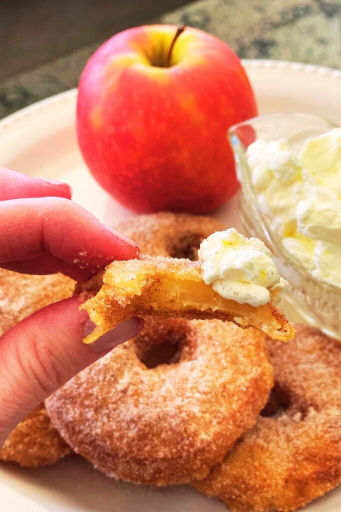 eating apple fritters dipped in cream.