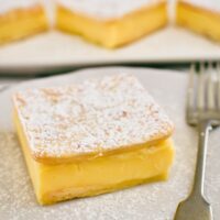custard slice on plate dusted with icing sugar.