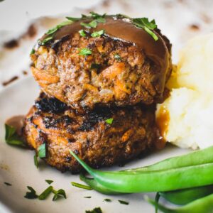 rissoles stacked on top of each other with a little gravy on top.