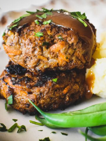 rissoles stacked on top of each other with a little gravy on top.