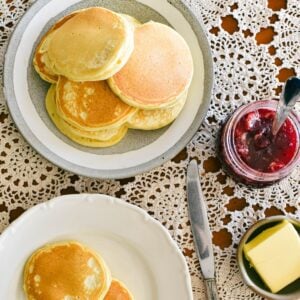 pikelets on plate served with butter and jam.