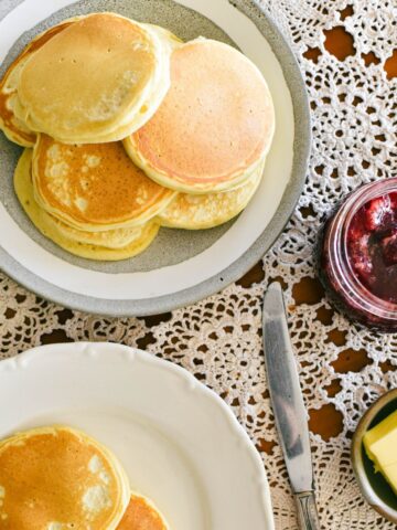 pikelets on plate served with butter and jam.