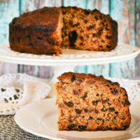 pineapple fruit cake slice on plabackground.te with whole cake on stand in