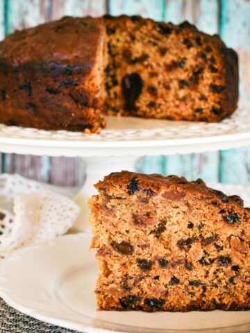 pineapple fruit cake slice on plabackground.te with whole cake on stand in