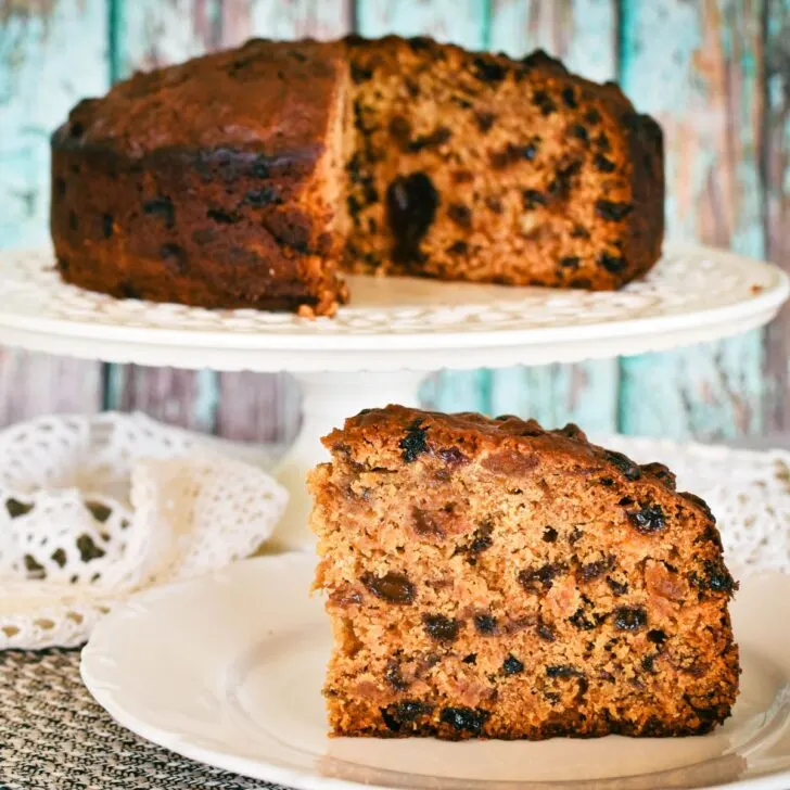 pineapple fruit cake slice on plabackground.te with whole cake on stand in