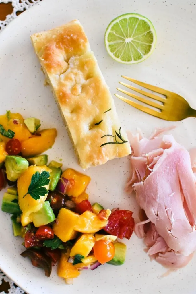 mango salsa served on plate with bread and ham.