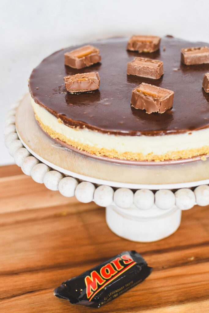 mars bar cheesecake on cake stand.