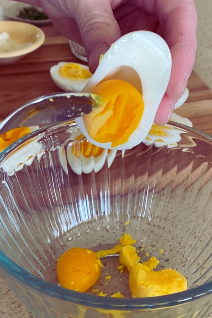scooping yolk from egg