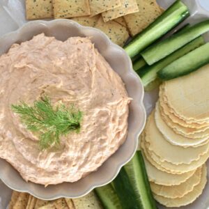 Salmon dip in dish surrounded by crackers.